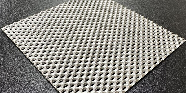 A platinum-plated titanium mesh placed on a dark gray tabletop.
