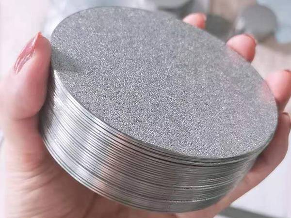 A man holding multiple porous stainless steel sintered discs